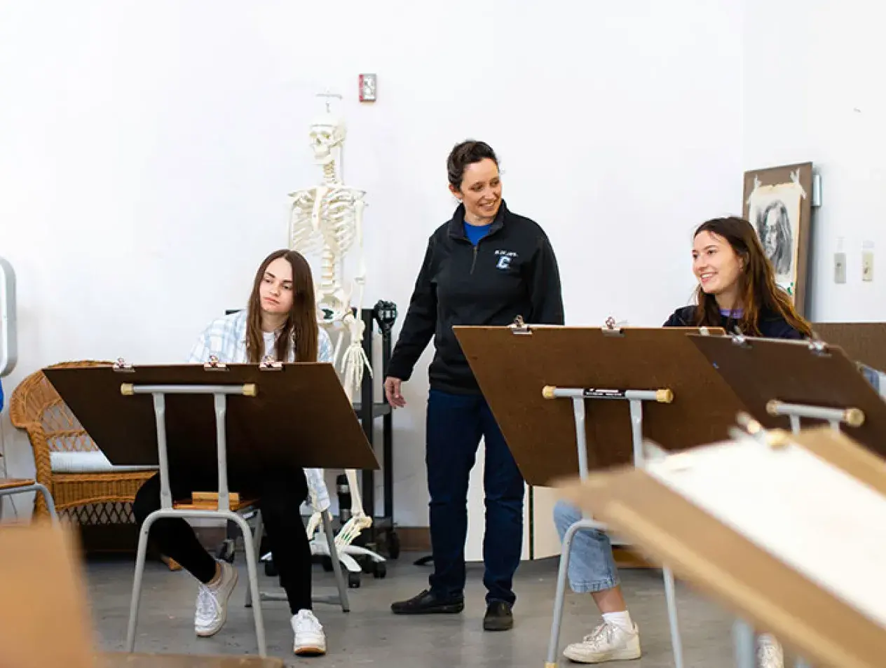 Faculty working with students in art studio