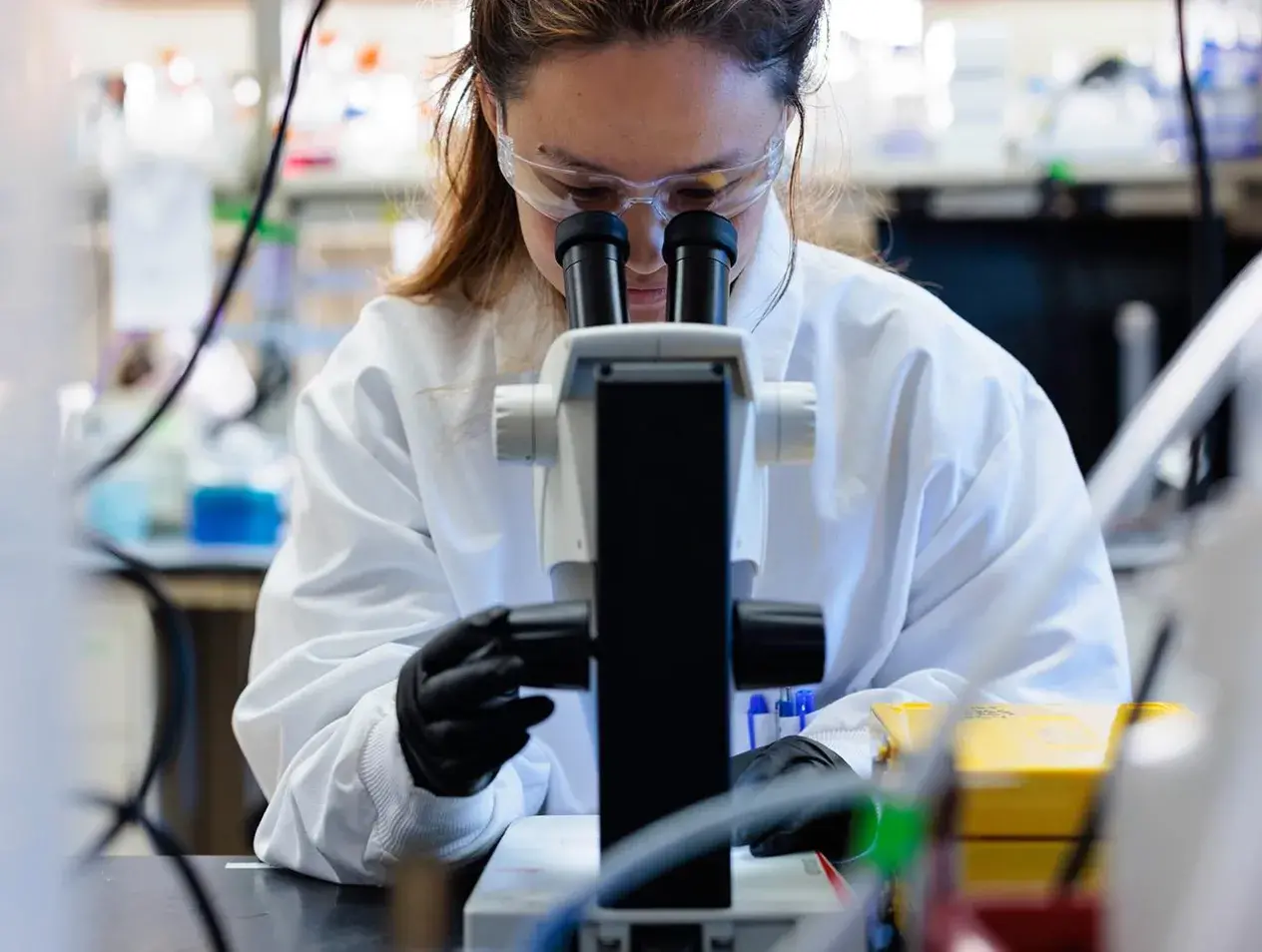 Biomedical science student using microscope