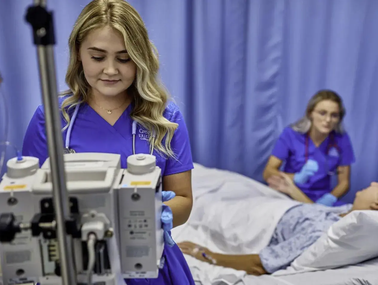 Nurses helping patient in bed