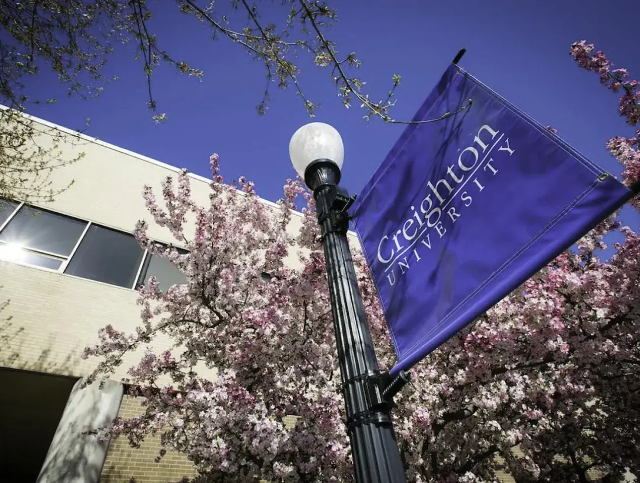 College of Law building with Creighton University banner outside on sunny day.