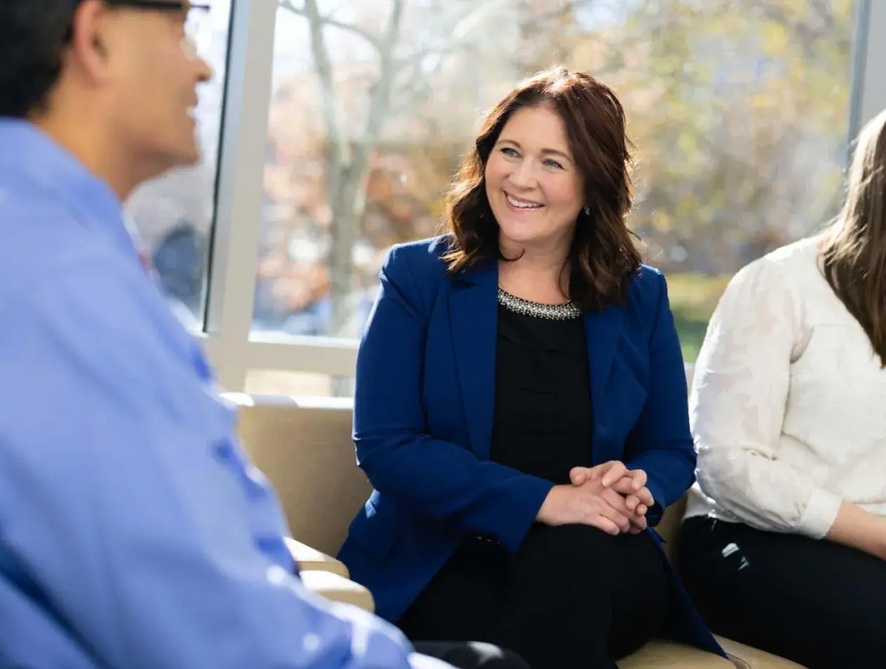 Executive healthcare colleagues talking while sitting on couch