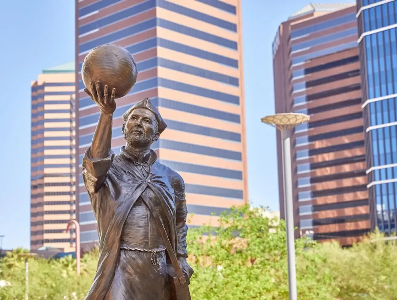 Phoenix campus with Jesuit statue pondering the world