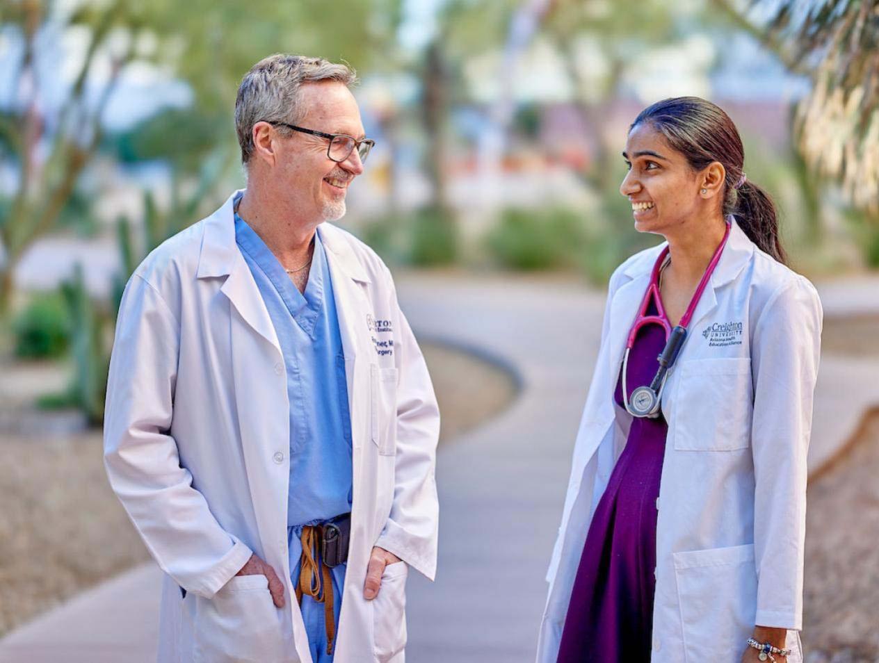 Doctor talking with resident on campus.