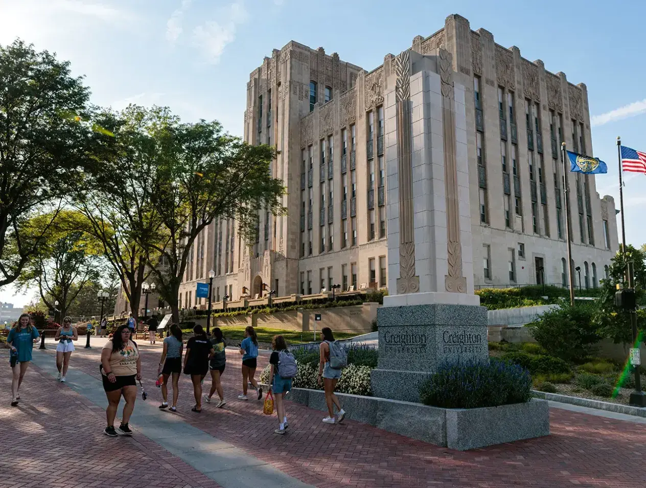 Students walking by Creighton Hall on the mall.
