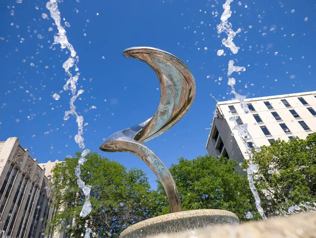 Fountain spurting in front of Flame sculpture.