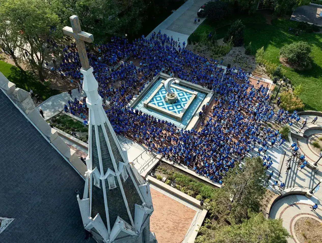 Overhead view of Creighton fountain surrounded by students in blue t-shirts.