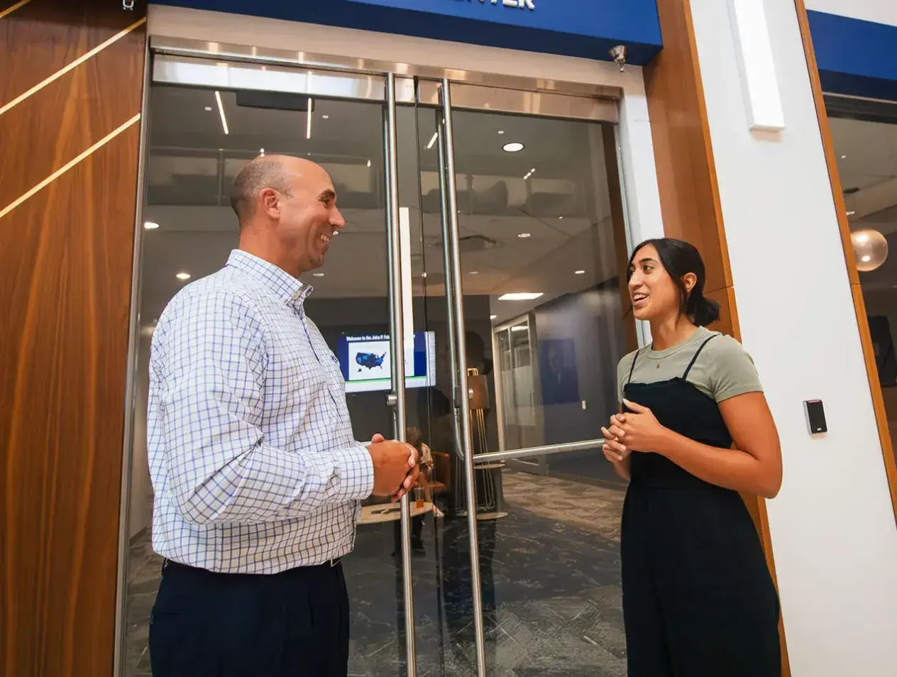 Student talking with staff member outside Career Center doors.