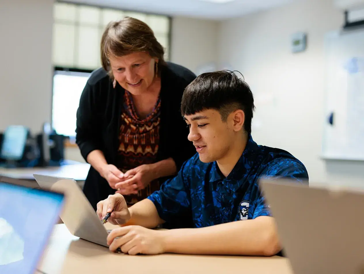 Faculty working with student at computer.