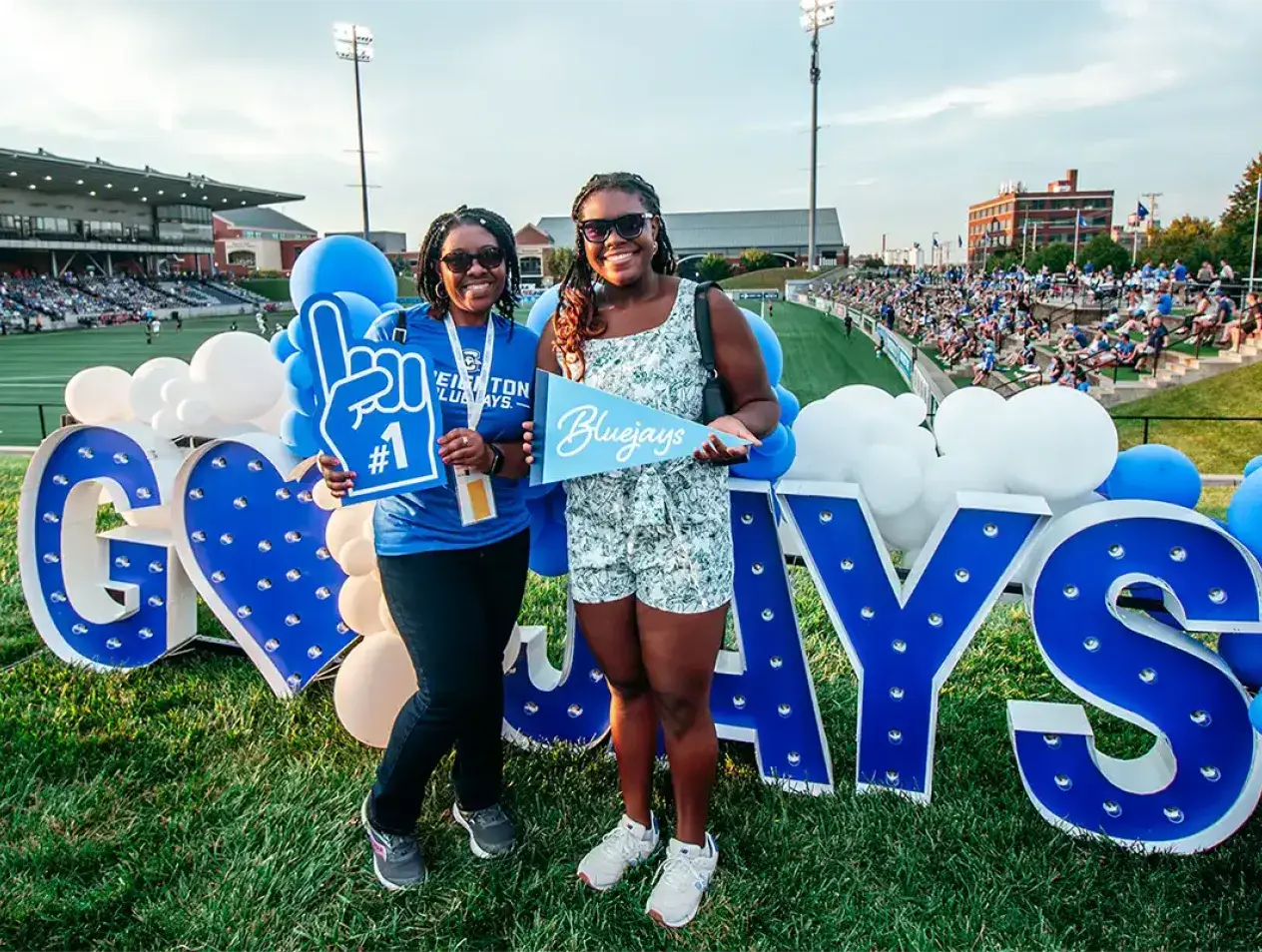 Alumni gathering at Creighton Days by Go Jays sign