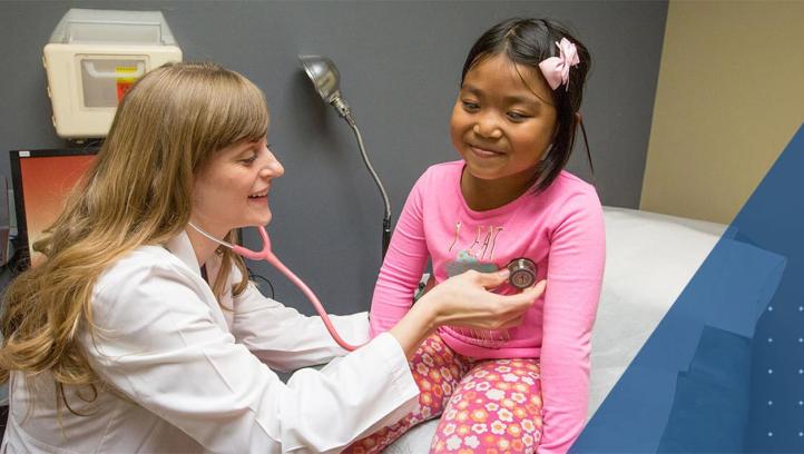 Female health professional listening to the heartbeat of a young girl.