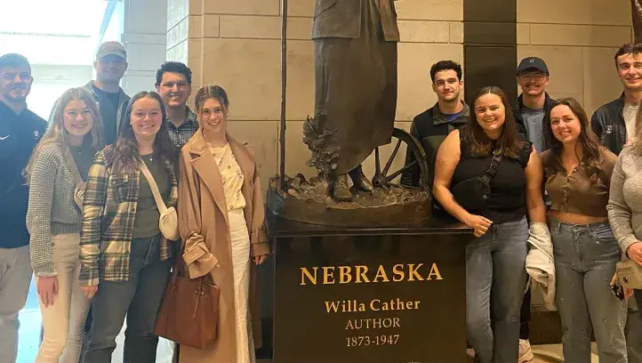 College of Arts and Sciences Dean's Fellows beside Willa Cather sculpture.
