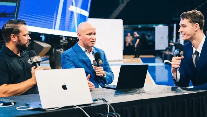 Kalkbrenner being interviewed on the set at a basketball game.