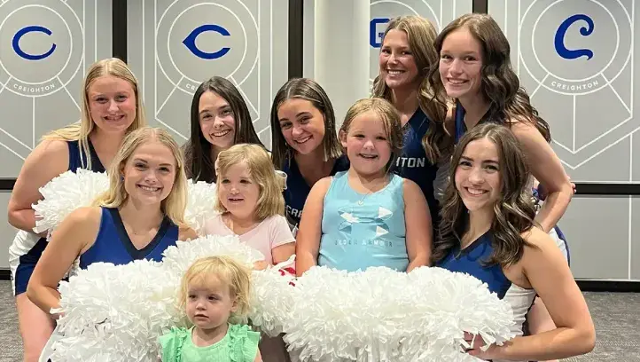 Creighton dance team posing with children.