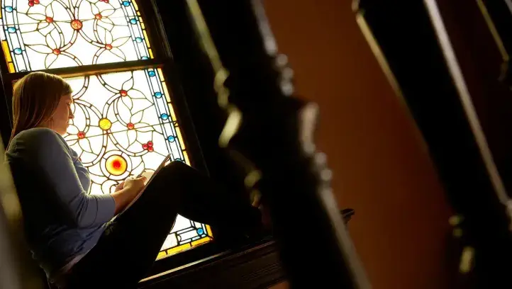Student studying in church setting.