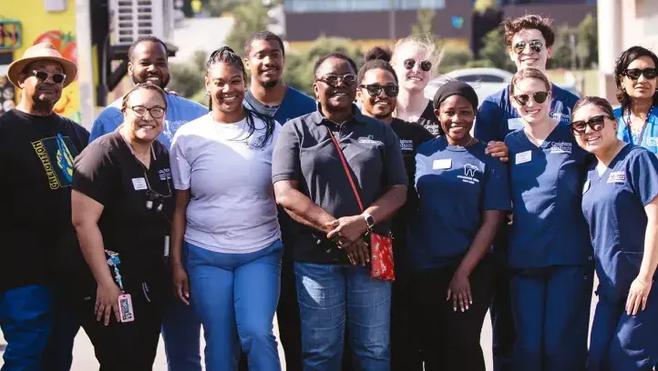 Nebraskans in group shot smiling on sunny day.