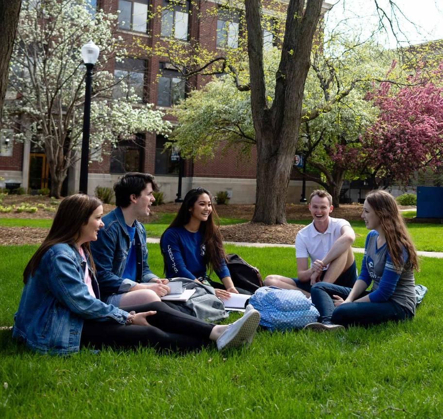 Creighton students sitting outdoors on campus lawn Thumbnail