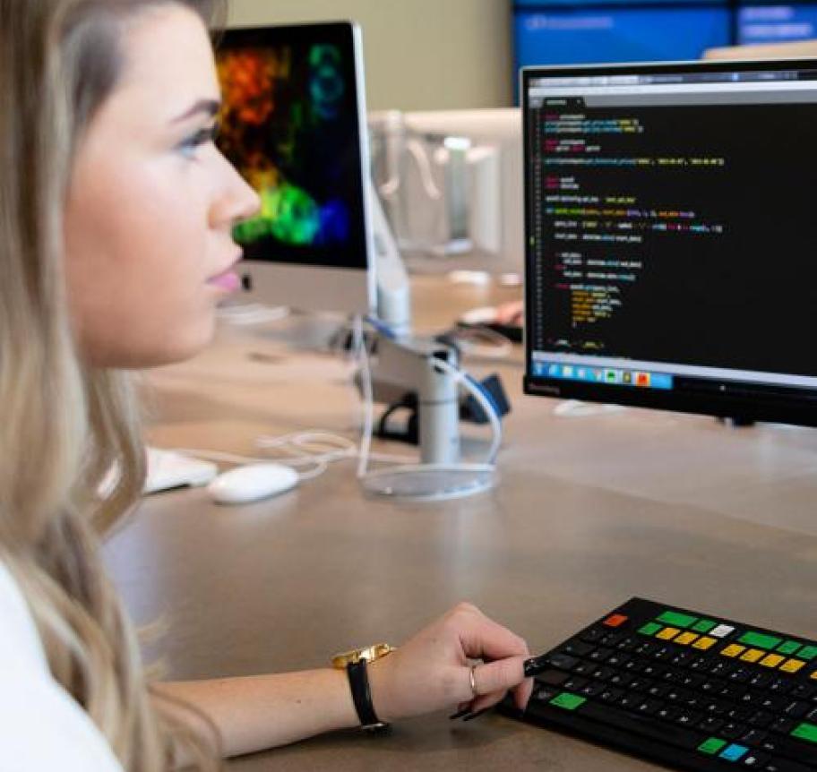 A woman studies code on a computer Thumbnail