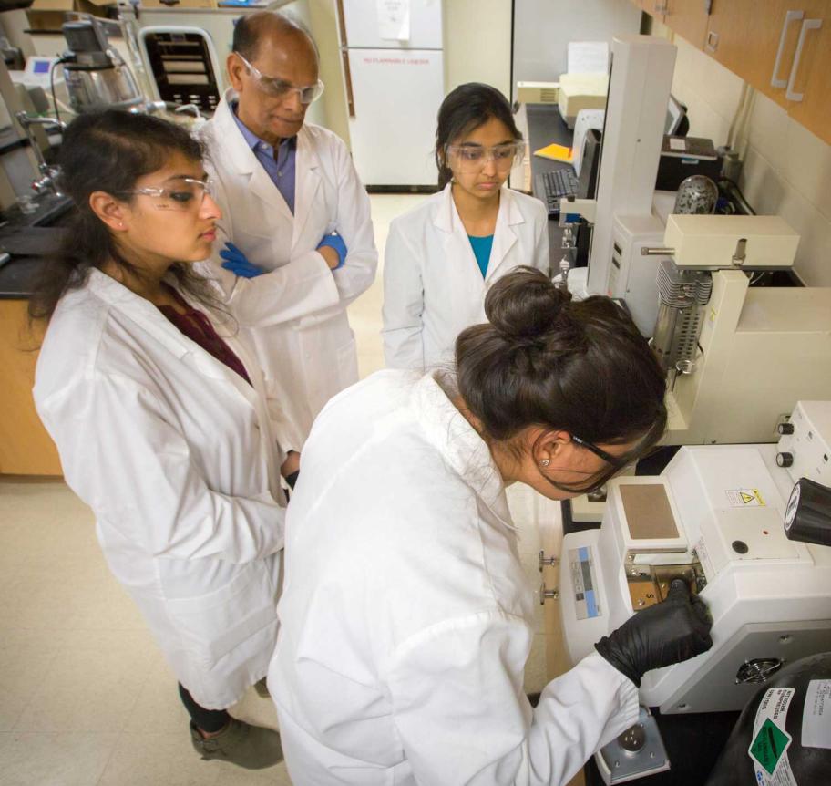Faculty observing students in lab