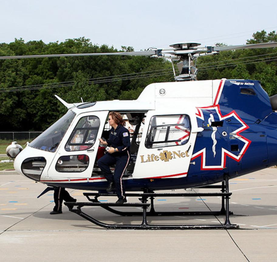 A critical care paramedic exiting a medical transport helicopter