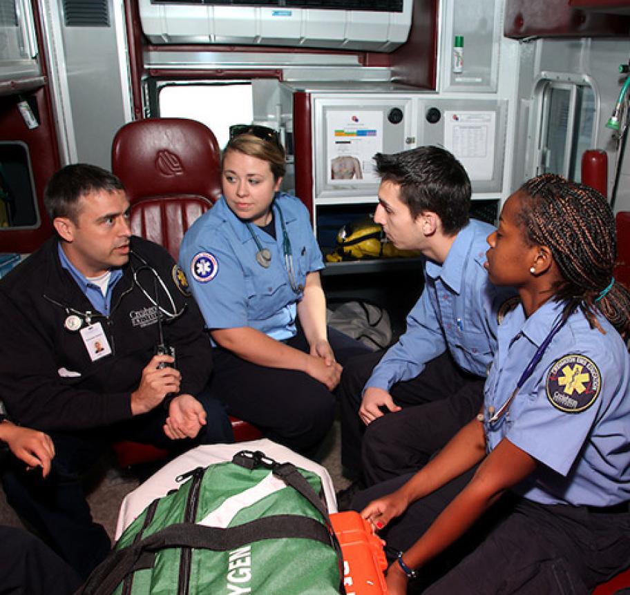 Paramedic students listening to their instructor in the back of an ambulance Thumbnail