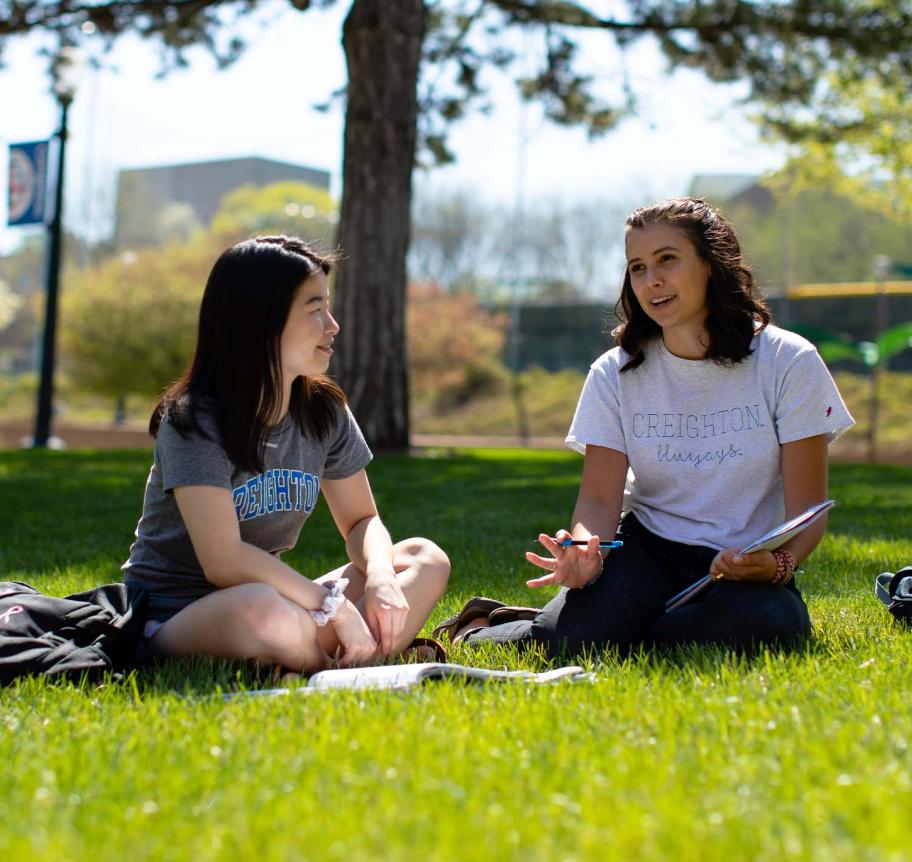 Students sitting in grass on Creighton campus