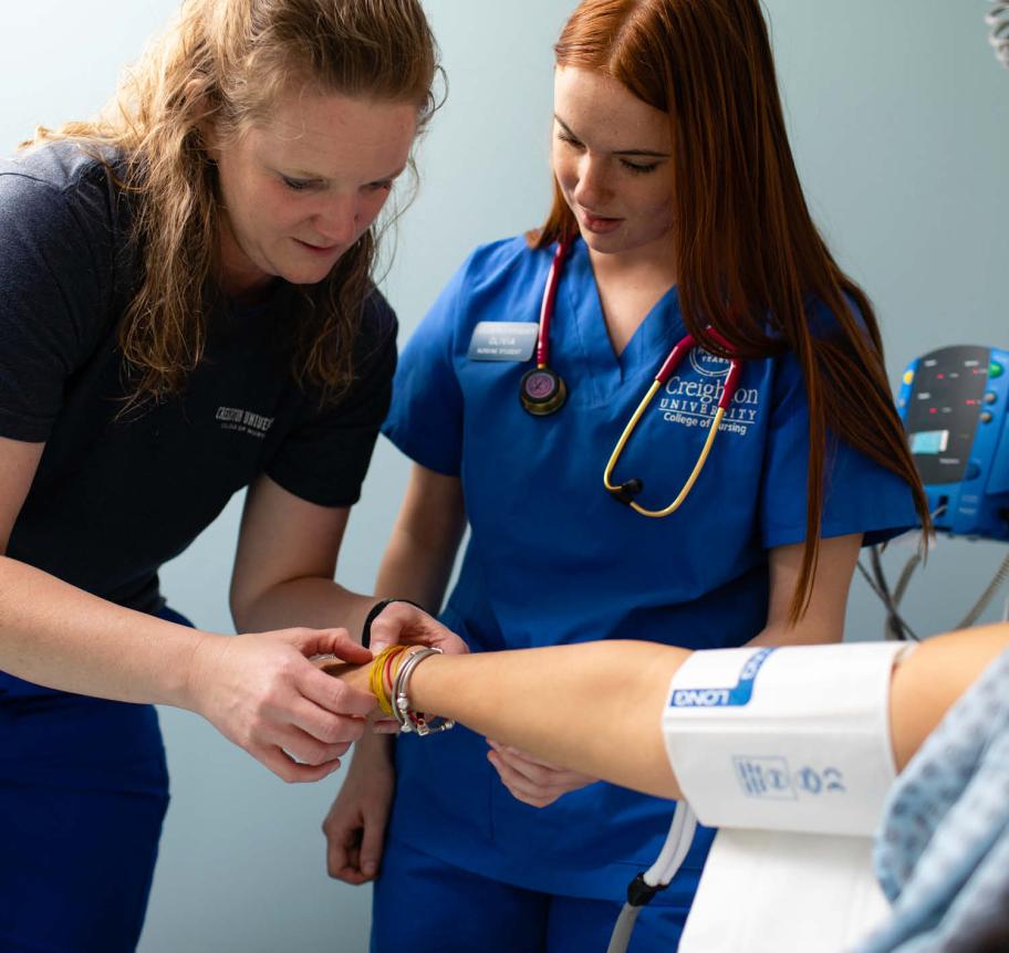 Nursing student doing hands-on learning with faculty