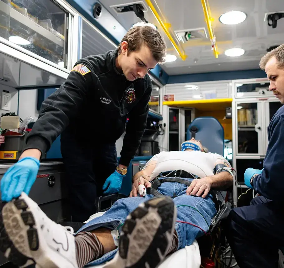 Two EMTs working on patient in ambulance.