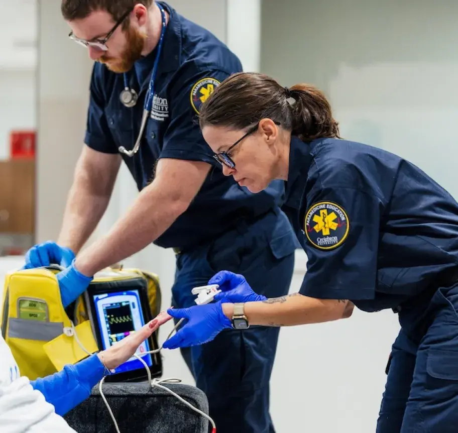 Two paramedics treating a woman.