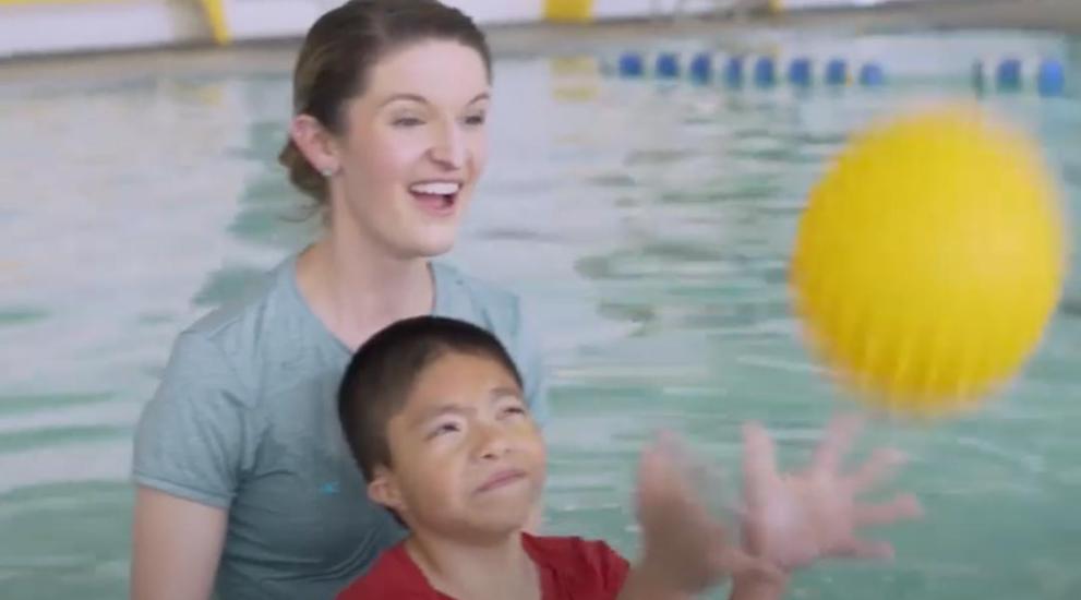 Pediatric patient catching ball in pool
