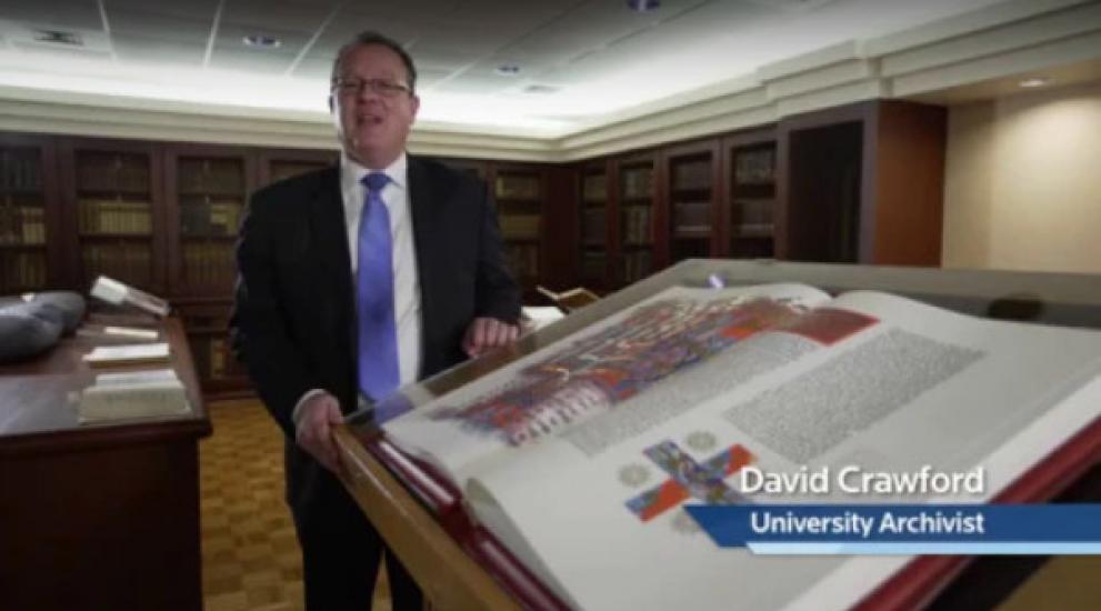 Video thumbnail featuring David Crawford, University Archivist, next to the St. John's Bible