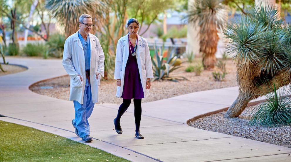 Alliance exterior doctors walking on sidewalk along palm tree path