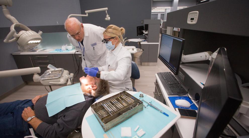 Creighton dental patient being treated by dentist and student
