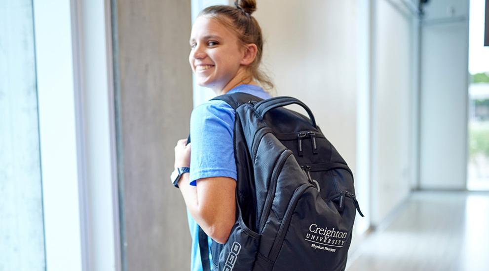 student with backpack smiling