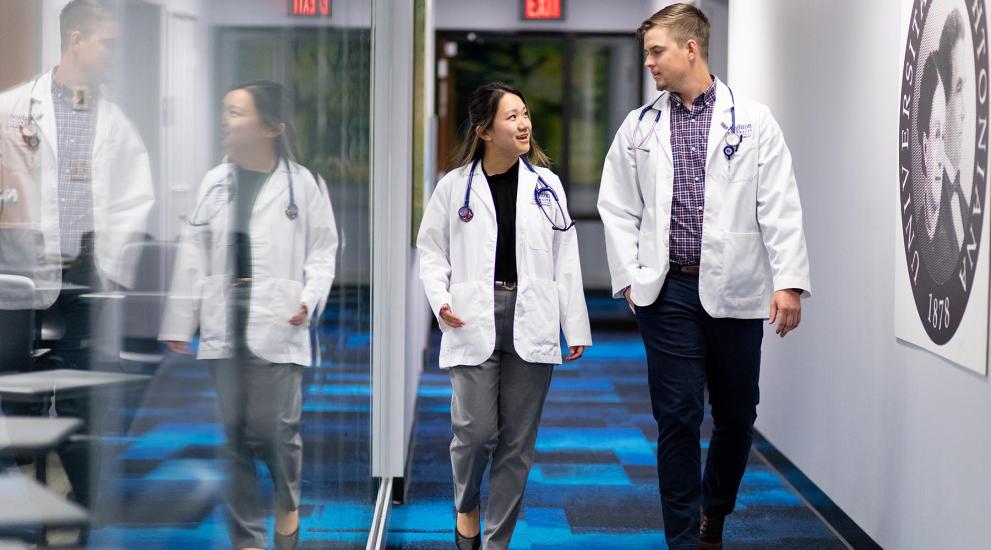 asian female and white male medical students walking