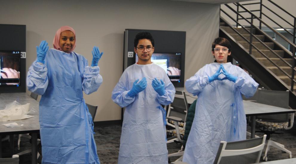 3 diverse students with medical gown and gloves on