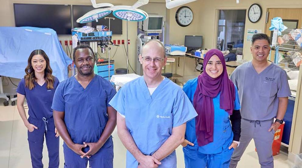 Surgery professionals in hospital posing for photo and smiling