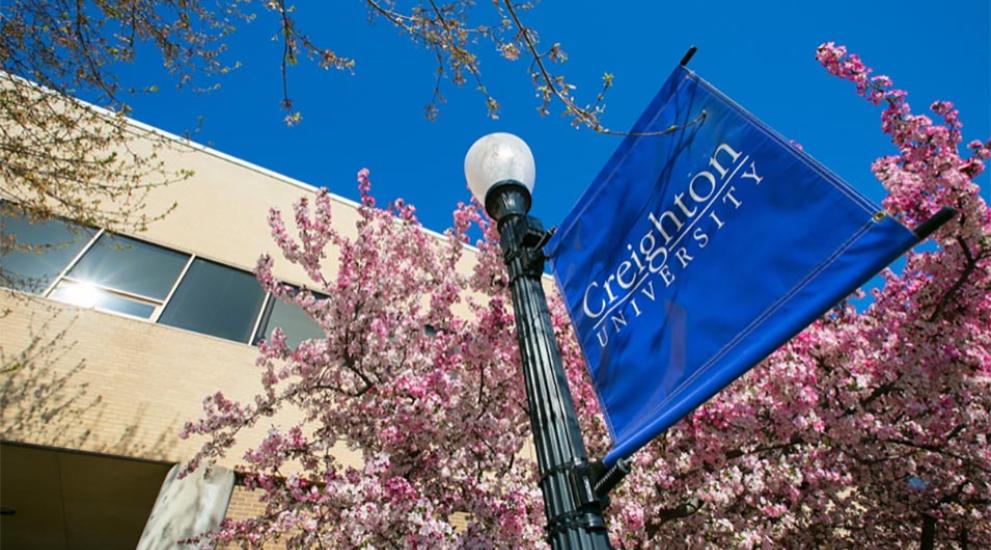 Creighton University blue banner outside law building.
