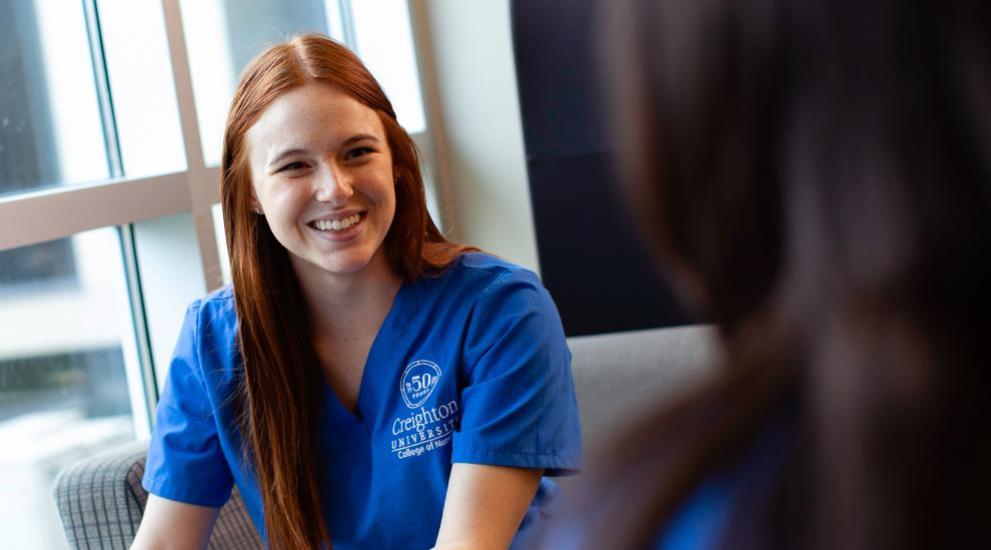 Nursing student smiling in lounge area.