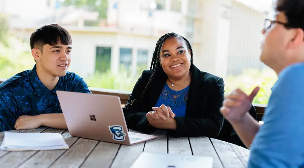 Admissions counselor meeting with students outdoors