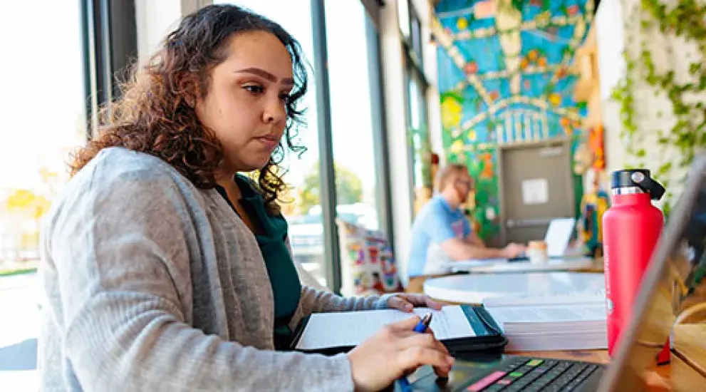 Professional studying at laptop in coffee shop
