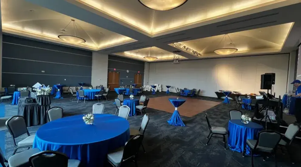 Round tables in ballroom with dance floor.