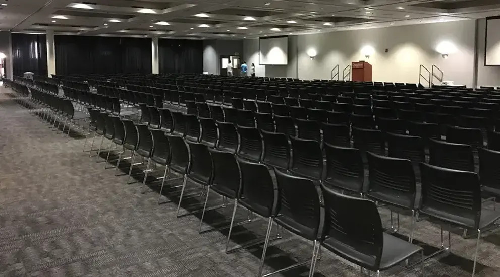 Large conference room with chairs, stage and podium.