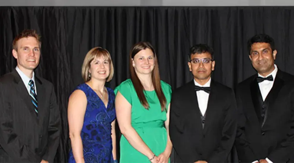 2016 General Surgery Residency graduation photo featuring five residents in business formal attire celebrating their program completion.