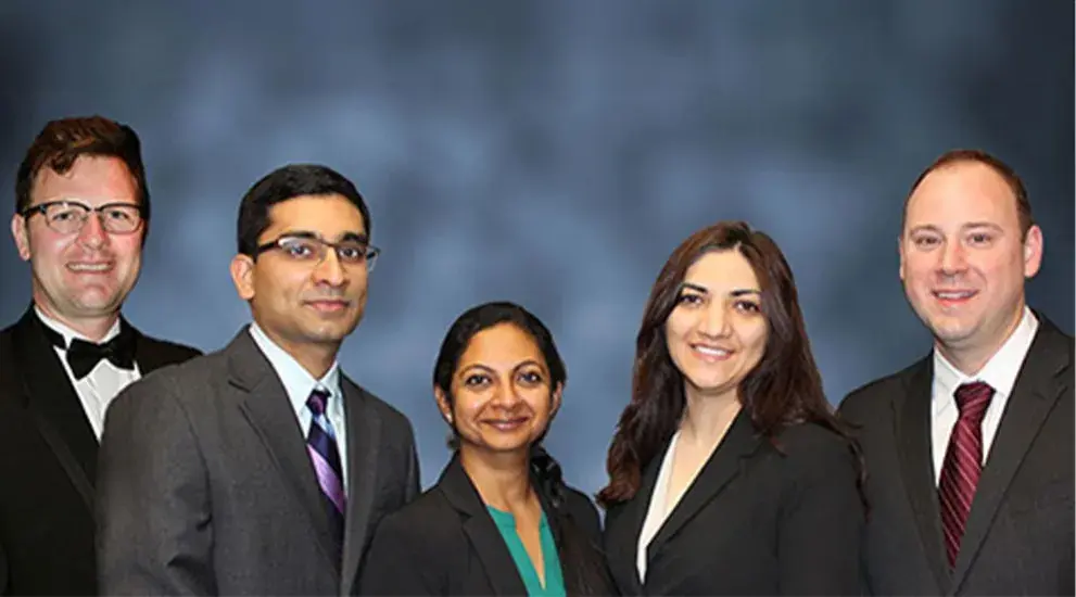 2018 General Surgery Residency graduation photo featuring five residents in business formal attire celebrating their program completion.