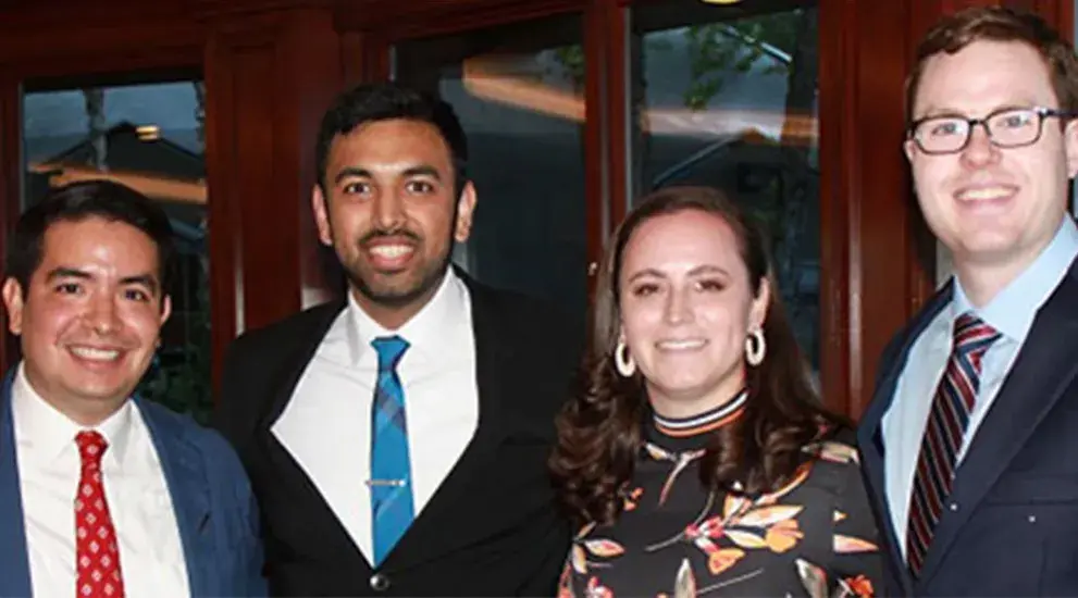 2021 General Surgery Residency graduation photo featuring four residents in business formal attire celebrating their program completion.